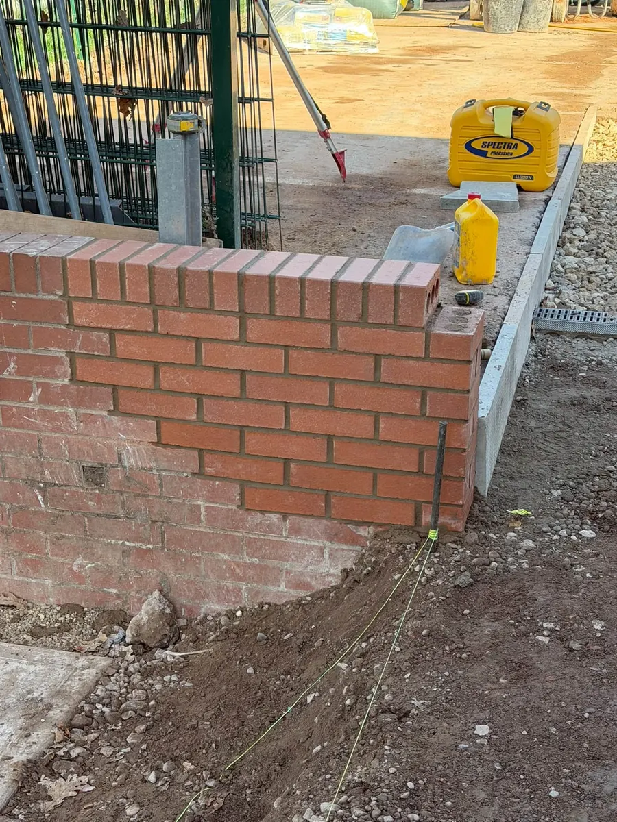 New brick wall on concrete edging, set out with a laser level, GRW Homes groundworks on a school project
