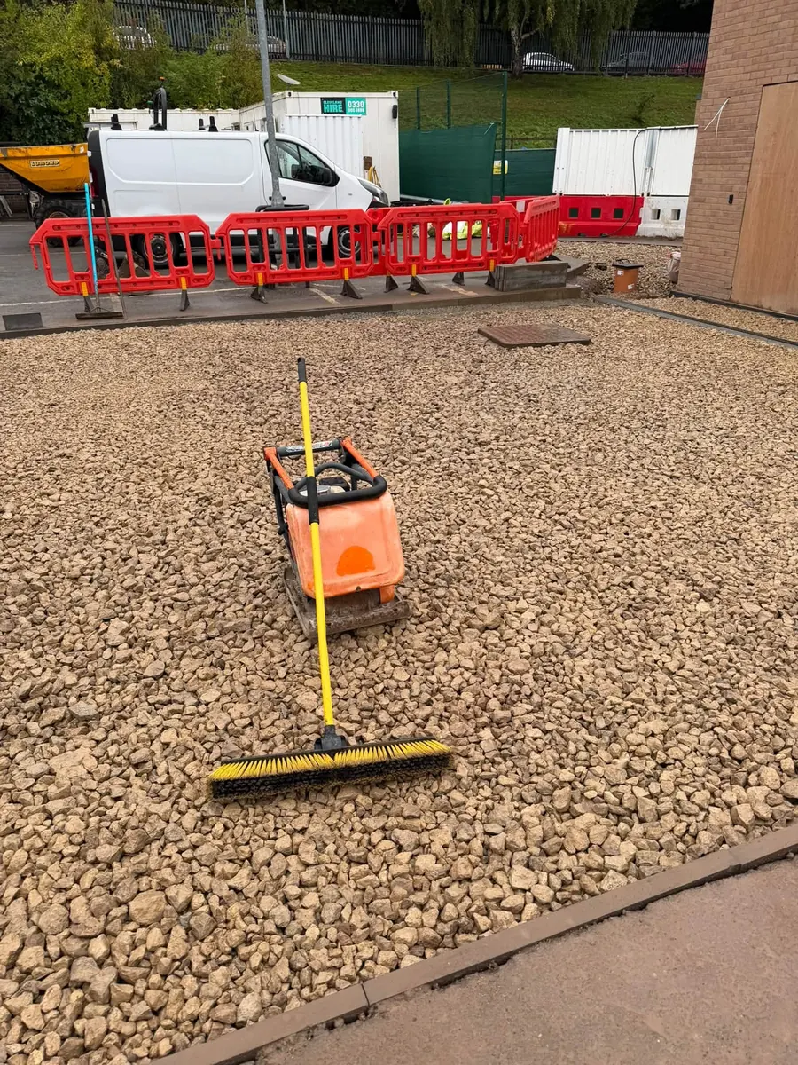 Plate compactor on fresh sub-base next to an Aco channel, GRW Homes groundworks on a school project