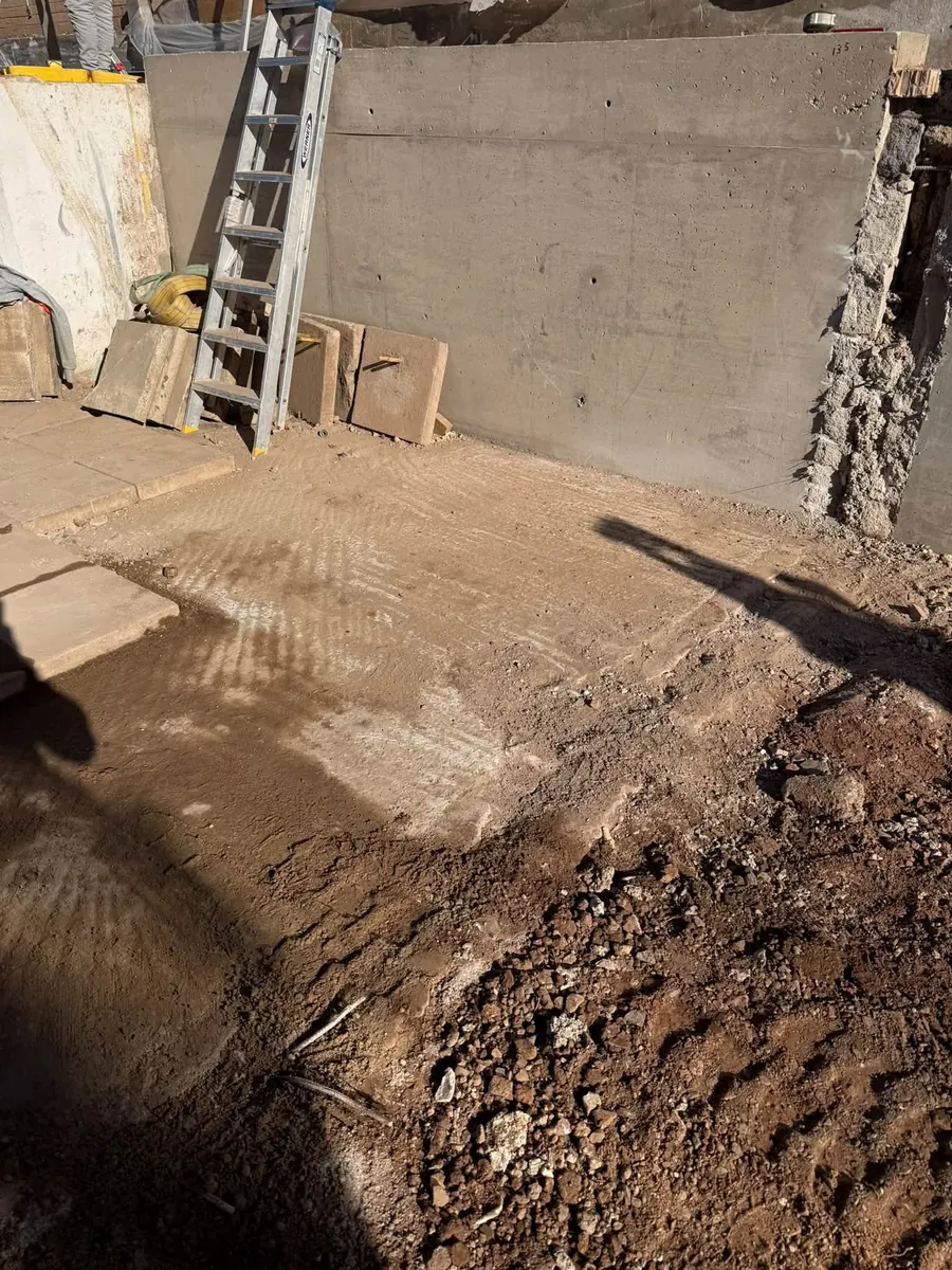 Base of a new concrete retaining wall with formwork board, GRW Homes groundworks on a school project