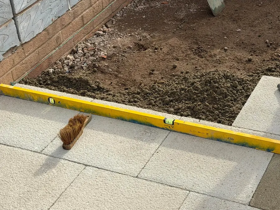 New slab paving with kerb edging, spirit level and brush, GRW Homes groundworks on a school project